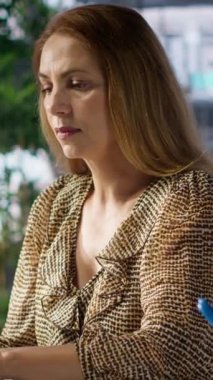 Dikey video profesyonel uzman ışınları son iş başarısını kutluyor. Kadın yönetici, iş başarısı elde etmenin hazzını yaşıyor ve bu da büyük bir atılım.