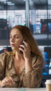 Dikey Video İşkadını sabit telefon görüşmesini kurumsal bir tartışma için kullanıyor. Kadın, dizüstü bilgisayarı üzerinde çalışırken kaynak tahsisi, mali planlama ve son teslim tarihi yönetimini tartışıyor