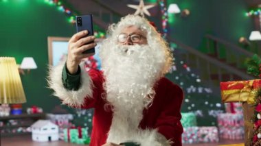 Yıllanmış Aziz Niklas, şenlikli X-mas takımını giyerek fotoğraf çekiyor, kış tatili gelenekleriyle eğleniyor. Noel Baba Noel ruhunu yaymak için telefonuna selfie çekiyor. Kamera A.