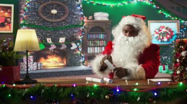 Afro-Amerikan Aziz Nick atölyesinde çocukların mektuplarını açıyor. Kırmızı takım elbiseli ve beyaz sakallı posta kutusunu kontrol ediyor. Bayram ışıklarıyla çevrili Noel Baba hediyeler hazırlar. Kamera B.