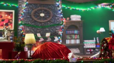 Afrikalı Amerikalı Noel hediyeleriyle dolu kırmızı çuvalını bağlıyor, çocuklara hediyeler dağıtmak için dünya turuna hazırlanıyor. Aziz Nick Noel kutusunu açıyor. Kamera A.