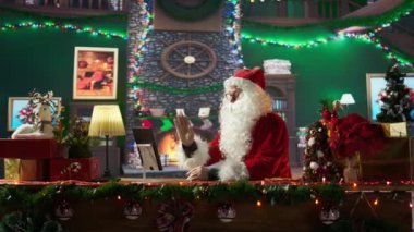 Aziz Nicholas, Noel tatili için hazırlık yapmadan önce, Kuzey Kutbu 'nda bir tablet kullanarak ebeveynler ve çocuklarla internet üzerinden sohbet ediyor. Büyülü bir karakter. Kamera B.