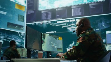 Askeri denetim odasında ordu personeli izleme sistemleri, verileri birleştiren ve stratejik görevleri koordine eden askerler bulunuyor. Karar verme ve verimliliği destekleyin. Kamera B.