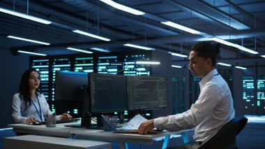 Veri merkezindeki sistem yöneticisi donanımın doğru belgelerini tutuyor, raporlar hazırlıyor. Yüksek teknoloji sunucu çiftliğinde bilişim uzmanı işyeri felaket kurtarma planı yapıyor, kamera B