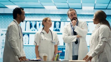 Tıbbi uzmanlardan oluşan bir ekip, kabinede holografik bir görüntü kullanarak teşhis verilerini ve hastane kayıtlarını inceliyor. Uzmanlar klinikteki hologramla ilgili tedavi planlarını inceliyor. Kamera A.