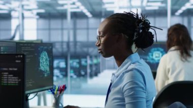 Makine öğrenme eğitimi için kullanılan yapay zeka veri merkezinde bilgisayar bilimcilerinin portresi. Sunucu merkezi ofisinde yapay zeka teknolojisi üzerinde çalışan neşeli bilişim uzmanı, kamera A