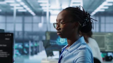 Sunucu odası sıralarını kontrol etmekle görevli gülümseyen kadın portresi farklı iş yükleri için bilgisayar kaynakları sağlıyor. Bilgisayar, kamera A kullanarak veri merkezi ana bilgisayarlarını araştıran mutlu yönetici.