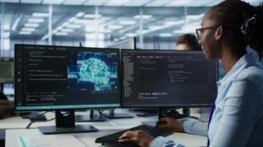 Yapay zeka veri merkezindeki kadın programlama, makine öğrenme eğitimi için kullanılan gelişmiş ekipmanlara ev sahipliği yapıyor. Yapay zeka teknolojisini geliştirmek için çalışan Afrikalı Amerikalı yönetici. B kamerasını kapat.