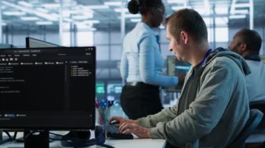 Sunucu merkezinde çalışan ve büyük miktarda veri işleyebilen bir adam. Klavyeye yazı yazan bilgisayar programcısı, ağ kaynaklarını kontrol eden sunucular güncelleniyor, kamera A