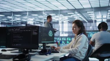 Yüksek teknoloji sunucu merkezinde çalışan iyimser bir bilgisayar bilimcisi muazzam miktarda veri işleme yeteneğine sahip. PC 'de gülümseyen kadın klavyede yazıyor, sunucular ağ kaynaklarını güncelliyor, kamera B