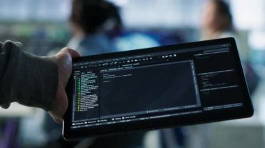 Veri merkezindeki bilgisayar bilimcisi tablet üzerindeki görevleri çözüyor, programlama senaryoları çalıştırıyor. Cihaz, kamera kullanarak yapay zeka geliştirme için kod satırlarını değiştiren mühendis.