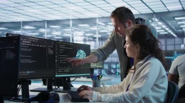 IT ekibinin üyeleri bilgisayardaki senaryoları programlıyor, yapay zeka öğrenimi uyguluyorlar. Yapay zeka uygulamaları için kodları manipüle eden yazılım geliştiricisi ve iş arkadaşı, kamera B