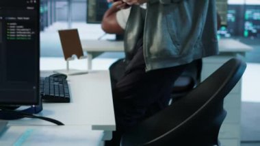 Teknisyen yüksek teknoloji sunucu odasına geliyor, monitörlerin verilerini analiz ediyor, kusursuz veri akışını sağlıyor. Veri merkezinde iş değişimine başlayan adam, sistem bütünlüğü ve güvenliği sağlama, kamera A
