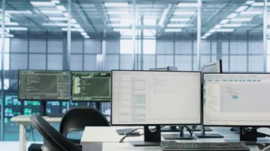 Boş veri merkezinin çalışma alanındaki bilgisayar ekranlarında kod çalıştırılıyor, sorun çözmede kullanılıyor. Masaüstünde çalışan betiği kapat PC monitörleri sunucu odasındaki ana bilgisayar sistemlerini güncelliyor