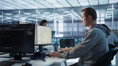 Mühendis, sunucu merkezinde büyük miktarda veri işlemek için kullanılan iş değişimine başlıyor. Bilgi işlem merkezine gelen bilişim programcısı, PC masasında oturuyor, klavyeye yazıyor, kamera B