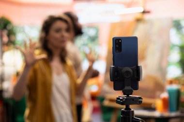 Dişi sanatçı, çevrimiçi öğretim görevlilerinde kullanılan resim tekniklerini anlatıyor, insanlara tuvalde suluboya resim yapmayı öğretmek için bir vlog kaydediyor. Resim dersi veren ressamlar takımı..