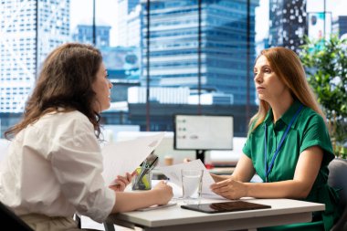 Job interview candidate interested in career advancement, talking with HR department worker. Woman talking with human resources staff member to get hired for top level company position clipart