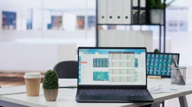 Boş çalışma alanındaki şirket masasındaki dizüstü bilgisayar cihazı değişken borsa fiyatlarının yükseldiğini ve düştüğünü gösteriyor. Önx ticaret platformları indeksleri aygıt ekranında olan komisyon firması