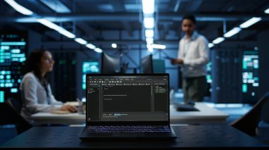 Veri merkezindeki laptop ekranında çalışan kodların kapatılması vites enerji tüketimini yönetmek için kullanılır. Sunucu çiftliğindeki bulanık arkaplanda yazılım geliştirici tarafından kullanılan dizüstü bilgisayara odaklan, kamera B