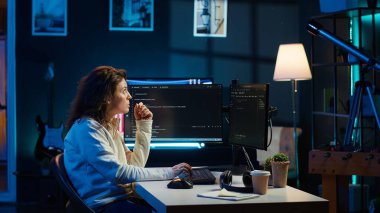 Bilgisayar ve artırılmış gerçekliği kullanarak şirketin güvenlik açıklarını ve virüslü yazılımları araştıran siber güvenlik uzmanı. Programcı bilgisayara kod yüklüyor, AR görselleştirmesine bakıyor, kamera A