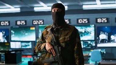 Terrorist occupying enemy base of operations, conducting guerilla warfare. Rebel forces hijacker with firearm in hidden war room starting offensive against opponents, camera A clipart