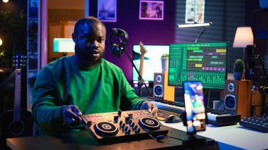 Yetenekli ses mühendisi tripodda akıllı telefon kullanarak kendini kayıt altına alarak çevrimiçi karışık müzik dersleri veriyor. Yapımcı, ses paneli teçhizatıyla ana sınıfı ağırlıyor. Kamera B.