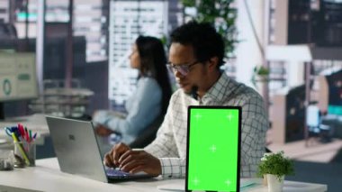 Kurumsal işadamı, veri analizlerini model ekranın yanında gözden geçiriyor, projenin ilerlemesini sağlamak için rapor yazıyor. Finansal planlamayı yöneten çok uluslu şirket çalışanı. Kamera A.