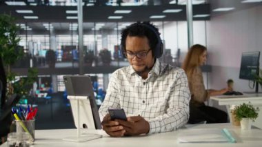 Çok uluslu bir şirkette yönetici asistanı kulaklıkla müzik yapıyor, iş projesinde birden fazla iş yapıyor. Profesyonel işlemleri yönetmek ve başarılı sonuçlar elde etmek için verileri kullanır. Kamera B.