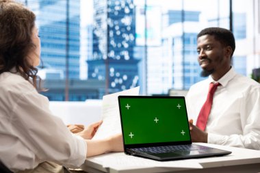 İnsan Kaynakları uzmanı şirket kültürüne uygun neşeli iş adayı adayıyla röportaj yaparken bilgisayar kullanıyor. İzole ekran defterinde gülümseyen başvuru sahibine maaş paketi sunan işe alım görevlisi