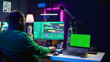 Besteci, profesyonel yazılım üzerinde şarkıları karıştırıyor ve ustalaştırıyor, izole edilmiş model ekran. Teknisyen ses efektleri ekliyor ve ses seviyelerini konsolla ayarlıyor, yeni müzik üretiyor. Kamera B.