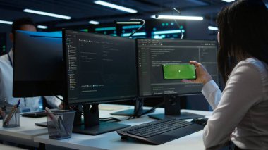 Veri merkezi çalışanlarının sorun çözme sorunlarının kullandığı yeşil ekran cep telefonunu yakınlaştır. Mühendis sunucu merkezinde modelleme akıllı telefon aygıtı kullanıyor, performans kriterleri oluşturuluyor, kamera B
