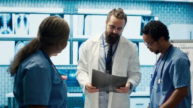 Radyologlar ve osteopatlar röntgen sonuçlarını inceler ve tedavi planlarını tartışırlar. Lisanslı çeşitli uzmanlar, kapsamlı tıbbi hizmetler sağlamak için özel bir klinikte çalışıyorlar. Kamera A.