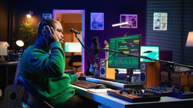 Profesyonel sanatçı, ev stüdyosundaki bir şarkı için yeni mısralar yazıyor, konsol ve bilgisayar yazılımlarını karıştırarak yeni müzik yapıyor. Besteci ses ekipmanları ve aletlerle çalışır, kayıt melodileriyle. Kamera B.