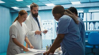 Sağlık ekibi insan anatomisini ve tanı stratejilerini muayenehanede tartışır. Toplu çalışma, doğru tedavi planlarını, profesyonel çözümleri, radyoloji uzmanlığını güvence altına alır. Kamera B.