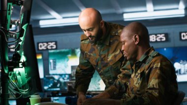 Askeri karargahtaki asker iş arkadaşıyla beyin fırtınası yapıyor, düşman birlikleri hakkında bilgi topluyor. Ekip çalışanları, izleme yazılımını kullanarak düşman savunmasızlıklarını ve kamera A 'yı değerlendiriyor.