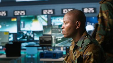 Kontrol odasında çalışan askeri ajanın portresi, hava keşif verilerini analiz ediyor. İstihbarat Teşkilatı Ajanı İHA 'ları kontrol ederek stratejik hedeflere saldırıyor.