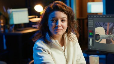 Video düzenleyici video montaj yaparken kullanılacak anahtar çerçeveleri seçiyor, bilgisayarla evden çalışıyor. Ofisteki film projesini düzenlemek için fareyi kullanan neşeli kadın, kamera A