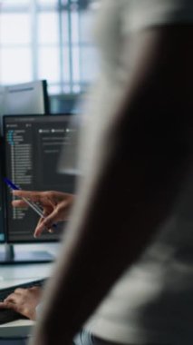 Bilgisayar kaynakları sağlayan AI sunucu odasında kontrol için bilgisayar masasında bekleyen bir mühendis var. Bilgisayar, kamera A kullanarak veri merkezini araştıran Afrikalı Amerikalı bir kadın.