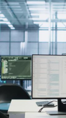 Boş veri merkezinin çalışma alanındaki bilgisayar ekranlarında kod çalıştırılıyor, sorun çözmede kullanılıyor. Masaüstünde çalışan betiği kapat PC monitörleri sunucu odasındaki ana bilgisayar sistemlerini güncelliyor