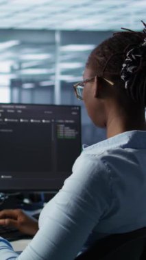 Bilgisayarlarda kod yazan ve ekipmanları güncelleyen bilişim destek çalışanları önünde izole edilmiş ekran tableti. PC masasındaki mühendisler sunucu kümelerini krom anahtar aygıtı, kamera B kullanarak denetlerler.