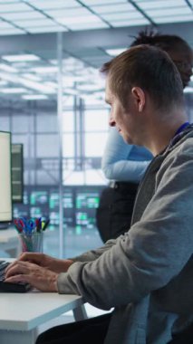 Sunucu merkezinde çalışan ve büyük miktarda veri işleyebilen bir adam. Klavyeye yazı yazan bilgisayar programcısı, ağ kaynaklarını kontrol eden sunucular güncelleniyor, kamera B