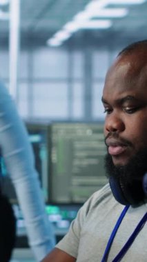 Yüksek teknoloji veri merkezi tesisinde meslektaşıyla birlikte çalışan mühendis donanım enerji tüketimini izliyor. Sistem arızalarını kontrol etmek için bilgisayar kullanan teknisyen ekibi, kamera A