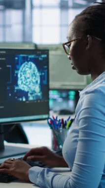 Yönetici, yapay zeka sinir ağlarının bakımıyla ilgili talimatları vermek için teknisyen masasına geliyor. AI sistem yazılımı kullanan denetleyici işçi, kamera A