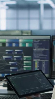 Veri merkezindeki bilgisayar bilimcileri, hesaplama işlemleri için yapay zeka sinirsel ağları kullanıyor. Yapay zeka öğrenme algoritmaları ve kamera A ile tablet üzerinde çalışan bilişim uzmanı.