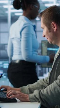 Sunucu merkezinde çalışan ve büyük miktarda veri işleyebilen bir adam. Klavyeye yazı yazan bilgisayar programcısı, ağ kaynaklarını kontrol eden sunucular güncelleniyor, kamera A