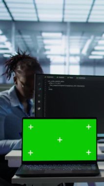 Kulaklıkla müzik dinlerken sunucu çiftliğinde programcının yanındaki izole ekran bilgisayarı. İşçi krom anahtar defteri, kamera B 'ye izinsiz erişime karşı donanımı koruyor