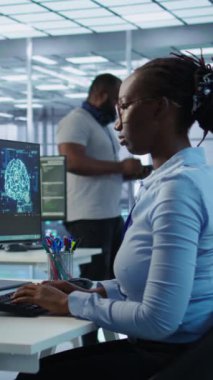 Yönetici, yapay zeka sinir ağlarının bakımıyla ilgili talimatları vermek için teknisyen masasına geliyor. Yapay zeka sistemi yazılımı kullanan denetleyici işçi, kamera B