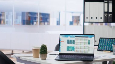 Bütçe hesaplama, öngörü ve finansal analiz amacıyla kullanılan teknolojiyle dolu boş bir finans bürosu. Parlak modern şirket çalışma alanı içinde kimse yok ve aygıtlar açık