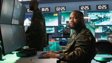 Komuta merkezindeki ordu ajanı küresel savaş sırasında gözetim verilerini analiz ediyor. Operasyon üssündeki istihbarat ajanı 3. Dünya Savaşı sırasında B kamerasındaki görevi tamamladı.