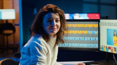 Gülümseyen fotoğrafçının portresi görüntü kalitesini artırıyor, kusurları düzeltiyor ve renkleri, kontrastı ve parlaklığı ayarlıyor. Ofis masasındaki fotoğrafları düzenleyen neşeli fotoğraf editörü, kamera A